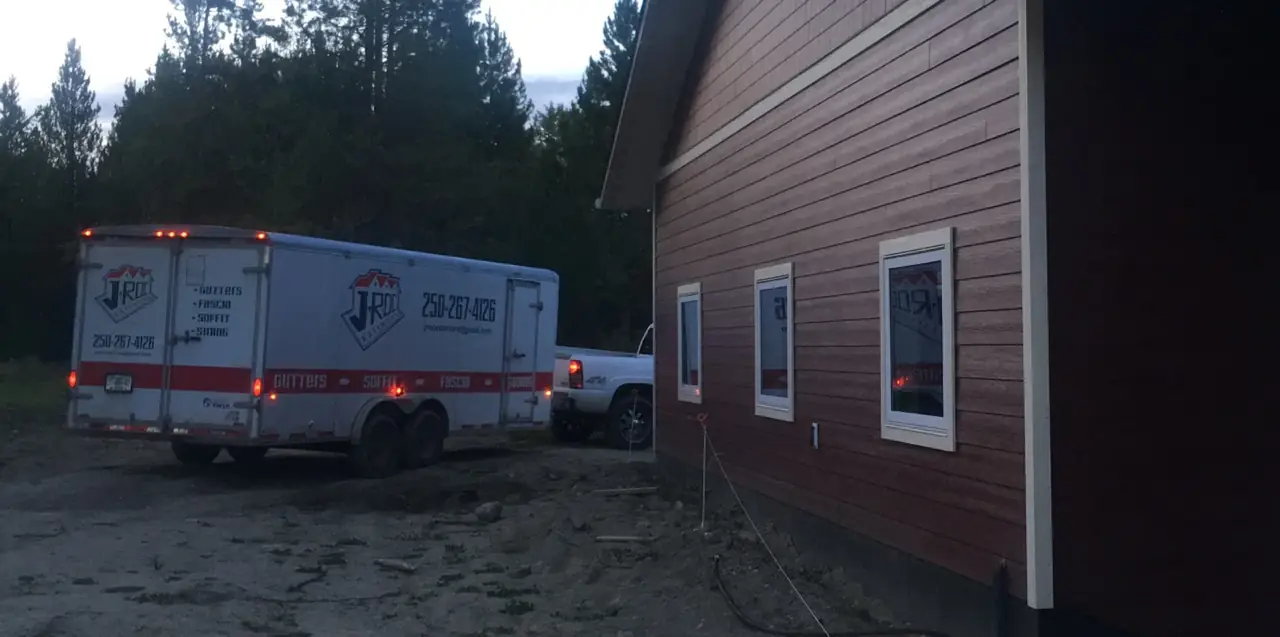 J-Roc Exteriors truck parked beside a red-sided building