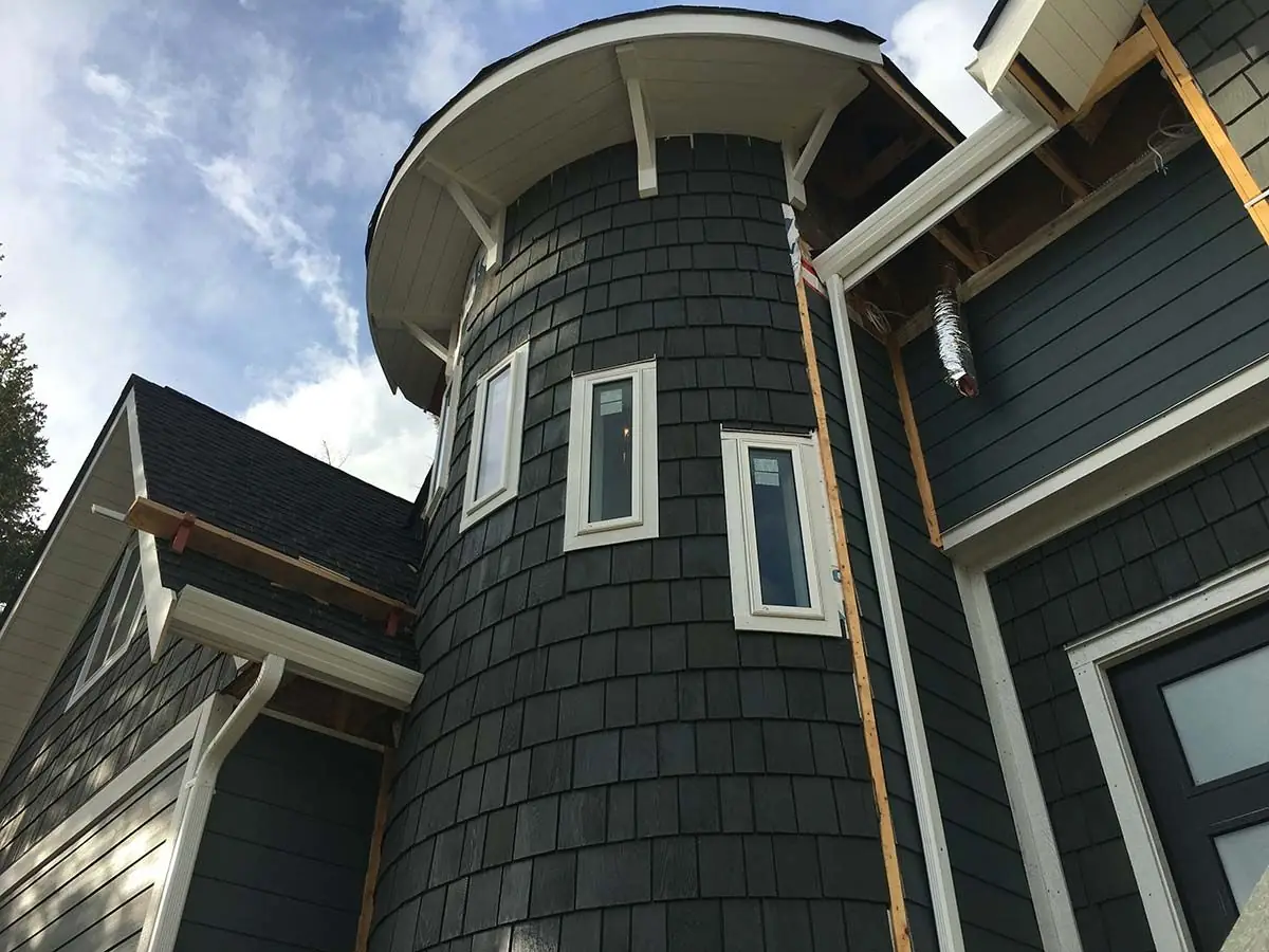 Cedar-shake style vinyl siding on a rounded turret
